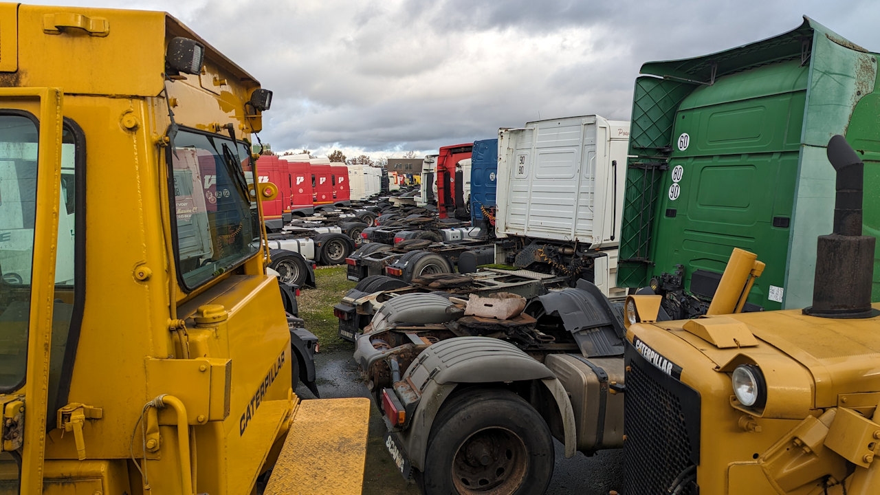 Bunte LKW Zugmaschinen in allen Farben parken auf einem Firmengelände 