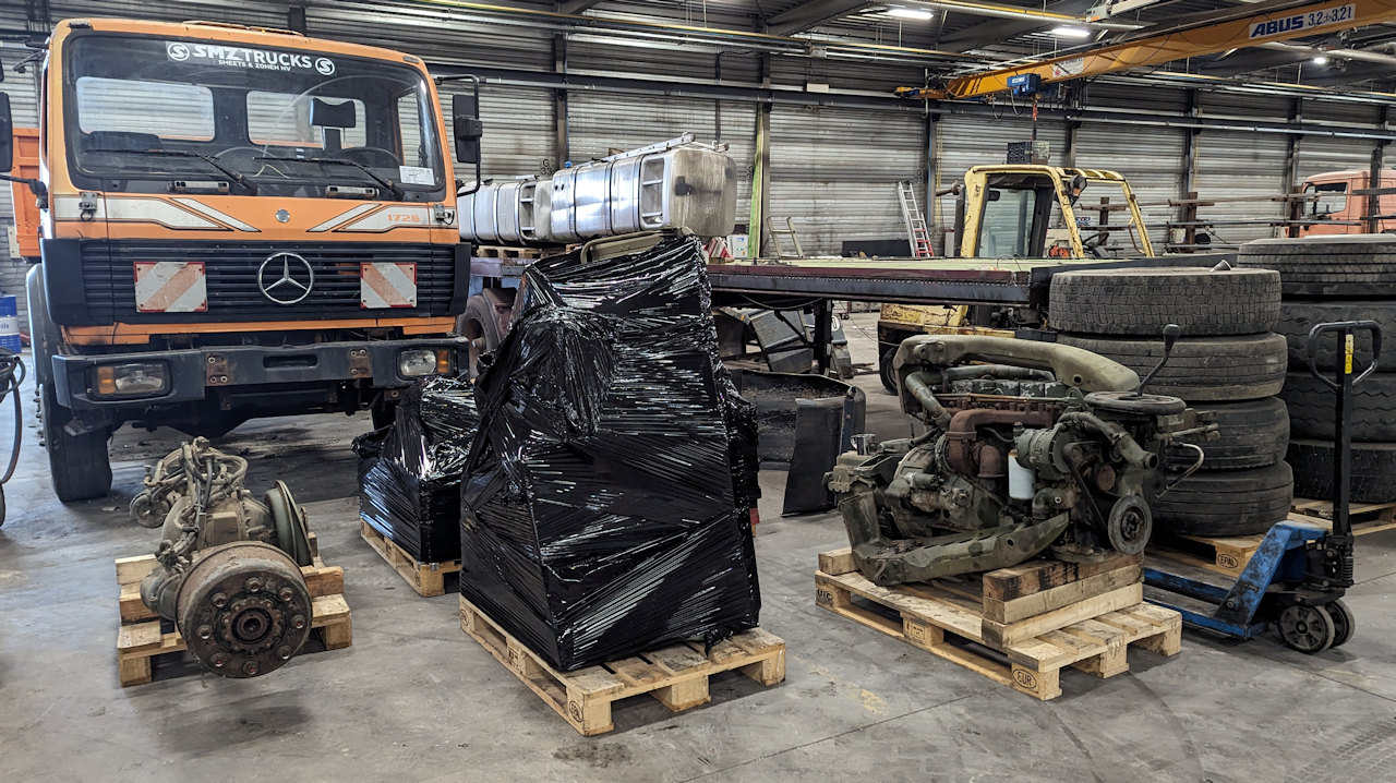 LKW Teile in einer Halle stehen verpackt auf Paletten