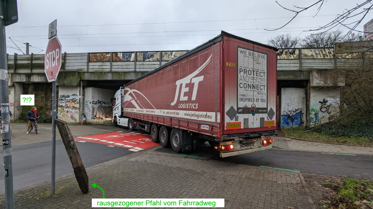 Ein LKW Trailer steht unter einer Eisenbahnbrücke quer und versperrt die Strasse. 