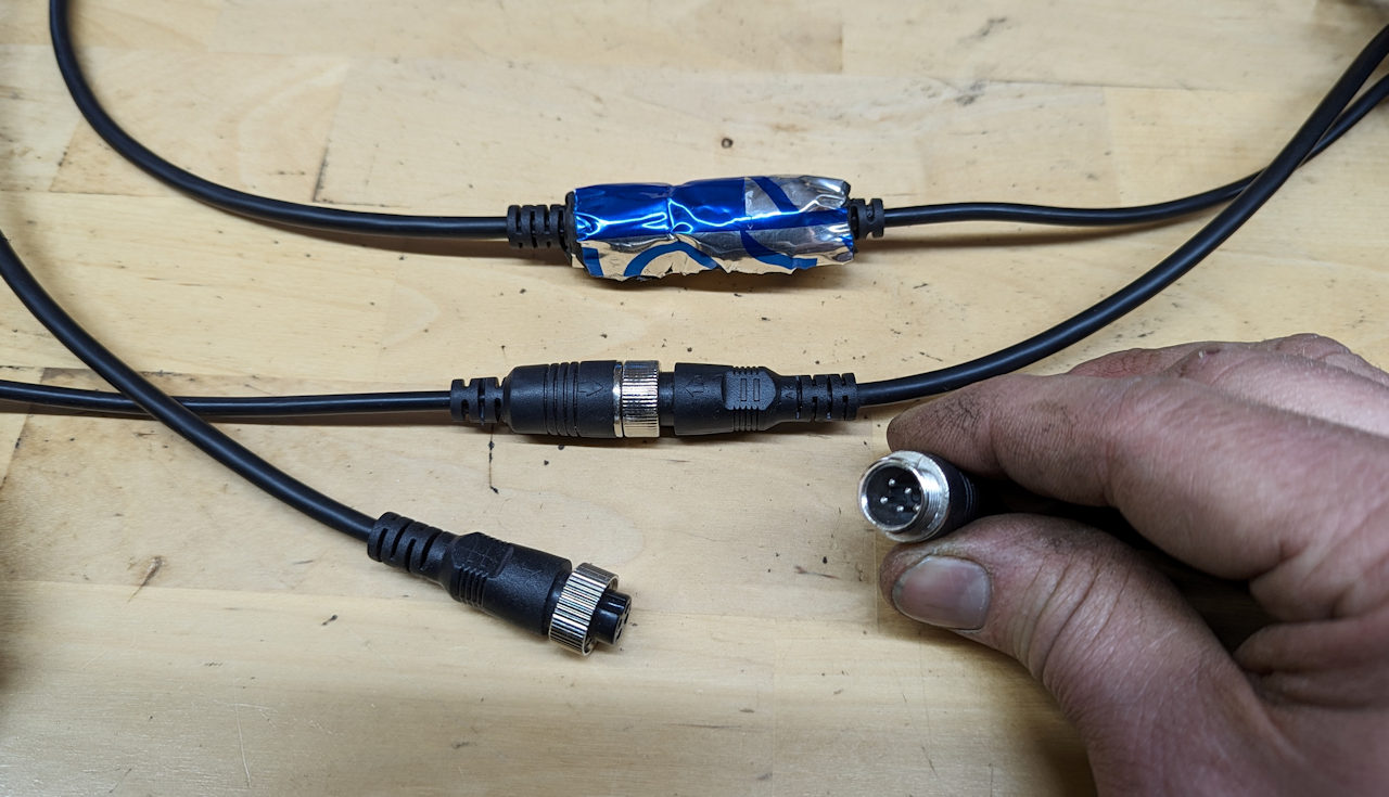 Drei Steckverbinder, von denen einer zur Isolierung gegen Feuchtigkeit mit Alubutyl umwickelt ist. 