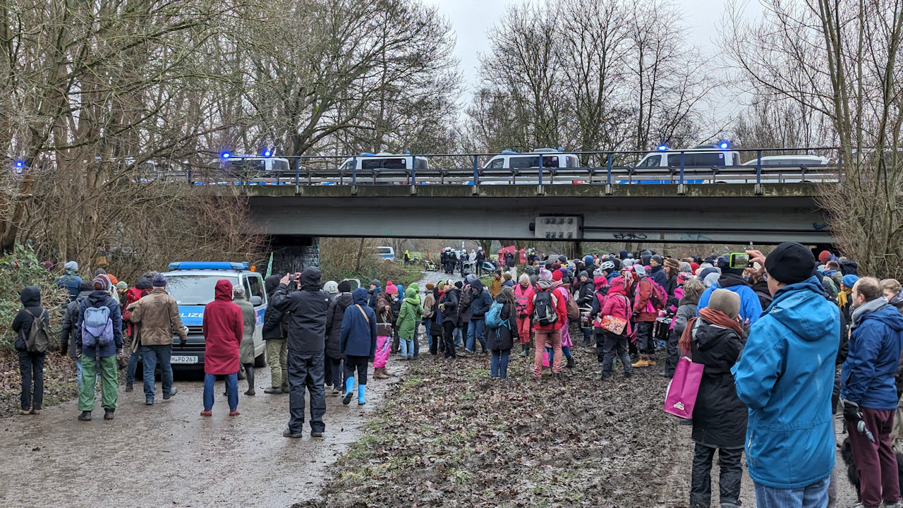 Menschen demonstrieren in Hannover gegen Baumfällungen, überwacht von Polizisten