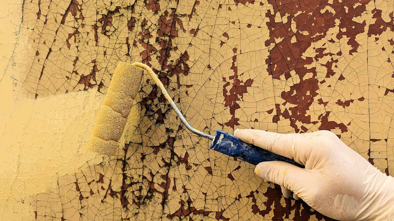 Rissige und ausgebleichte Farbe wird sandgelb überstrichen