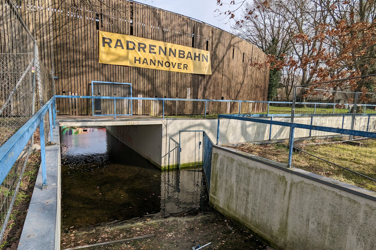 Radrennbahn Hannover Wülfel Aussenansicht. Eine Unterführung steht unter Wasser