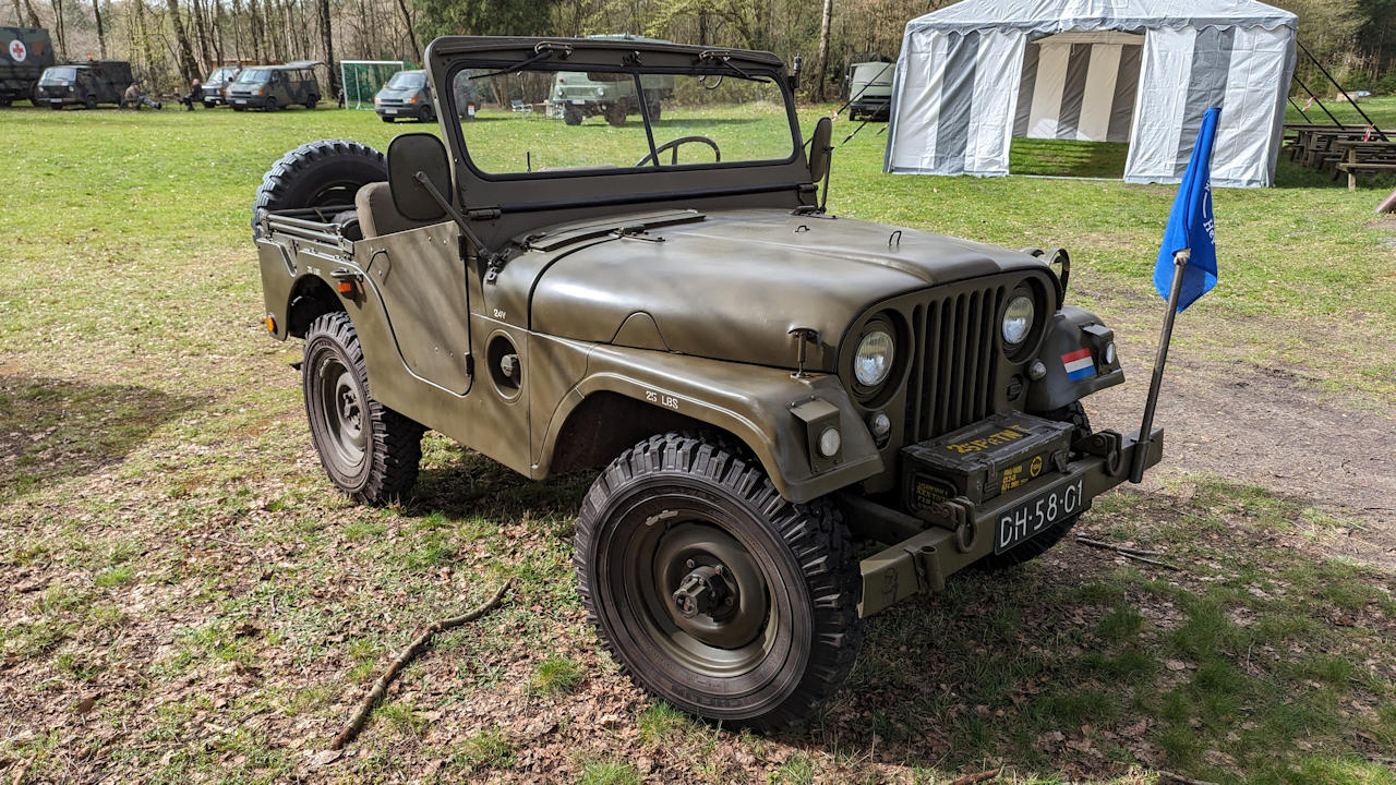 Olivgrüner Jeep mit blauer Fahne