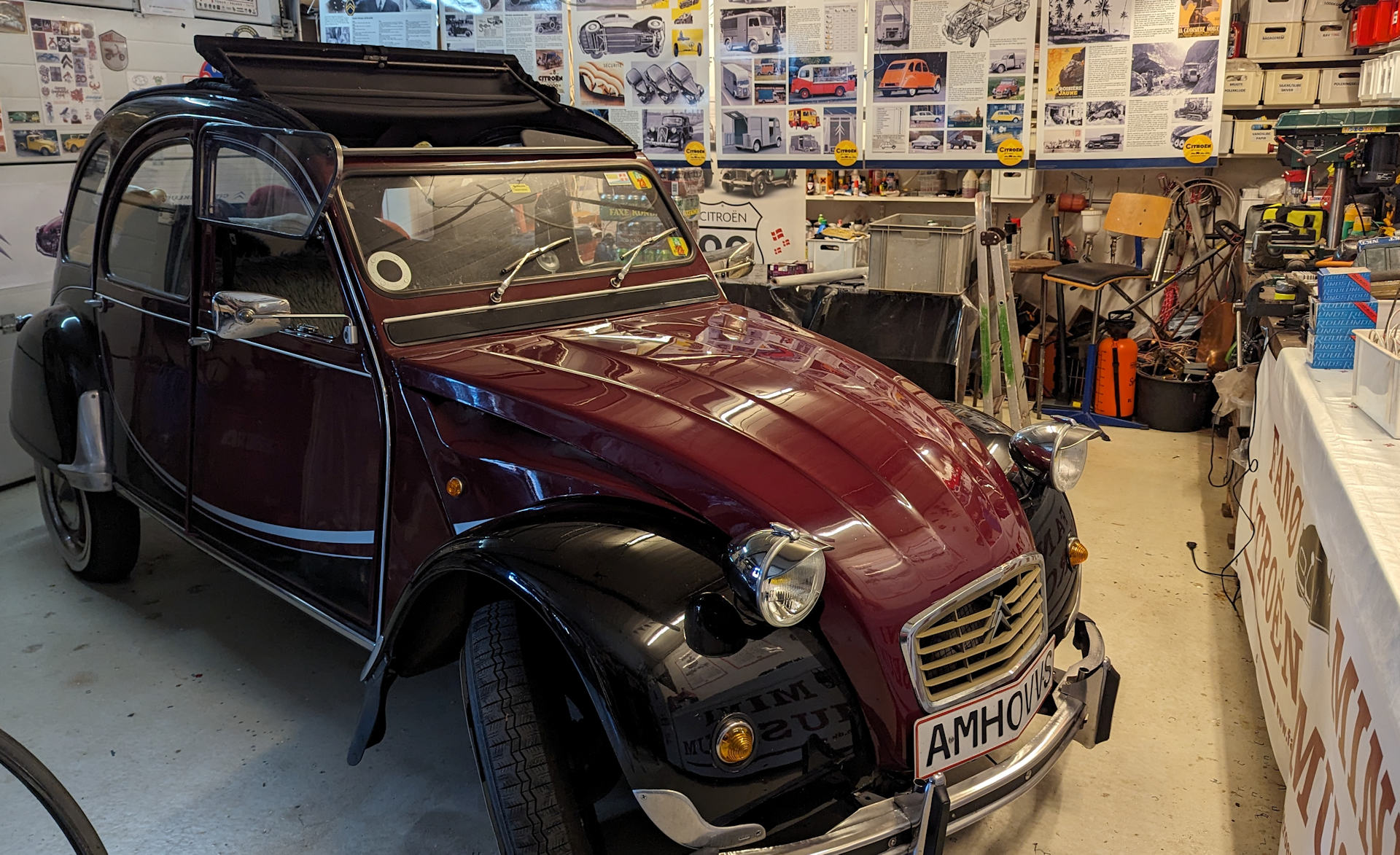 Weinroter Citroen 2CV vom Citroen Museum Sønderhoin einer Garage mit  Andenken und Fan Artikeln