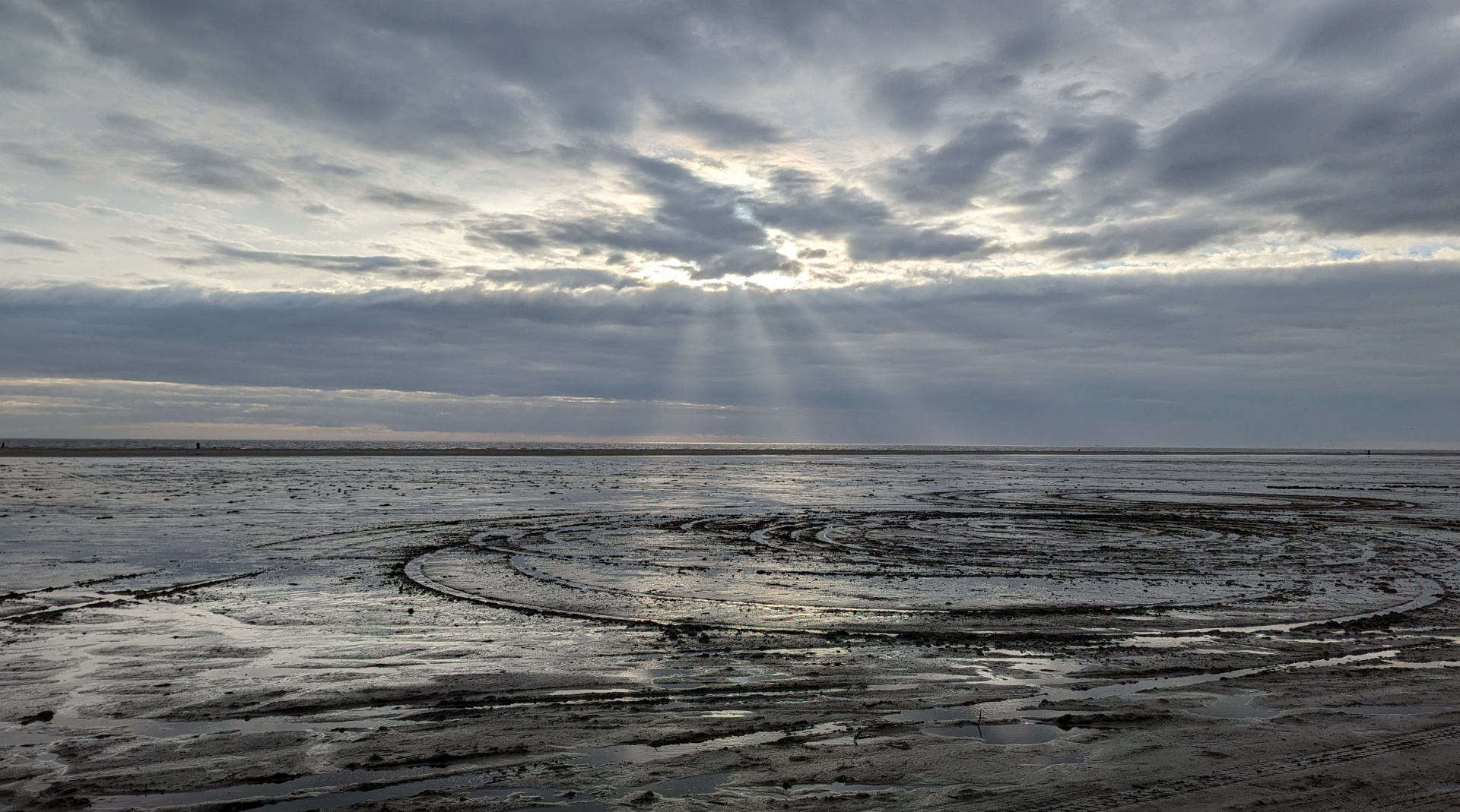 Watt Spätnachmittags am Meer. Sonne durchbricht mit einzelnen Strahlen die grauen Wolken