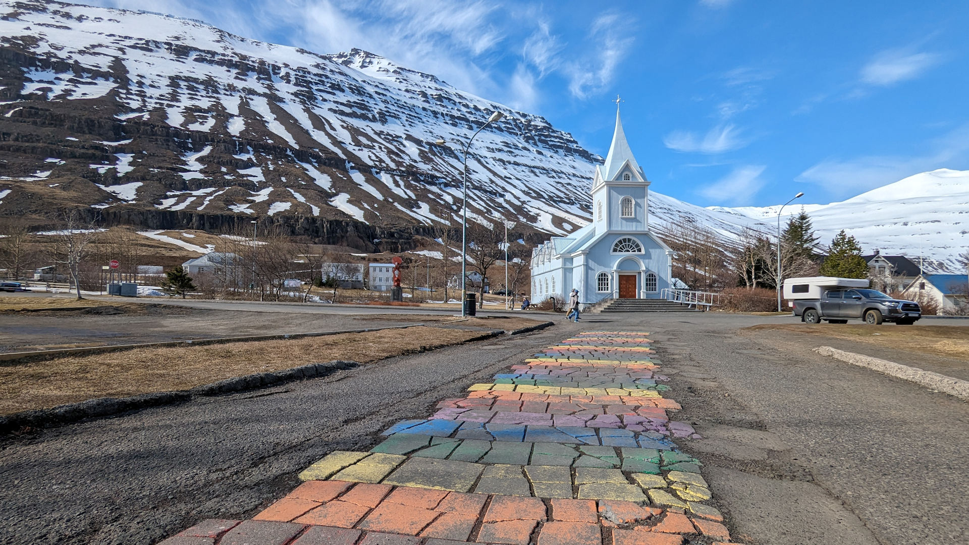 Blaue Kirche in Seydisfjördur mit bunt bemaltem Weg