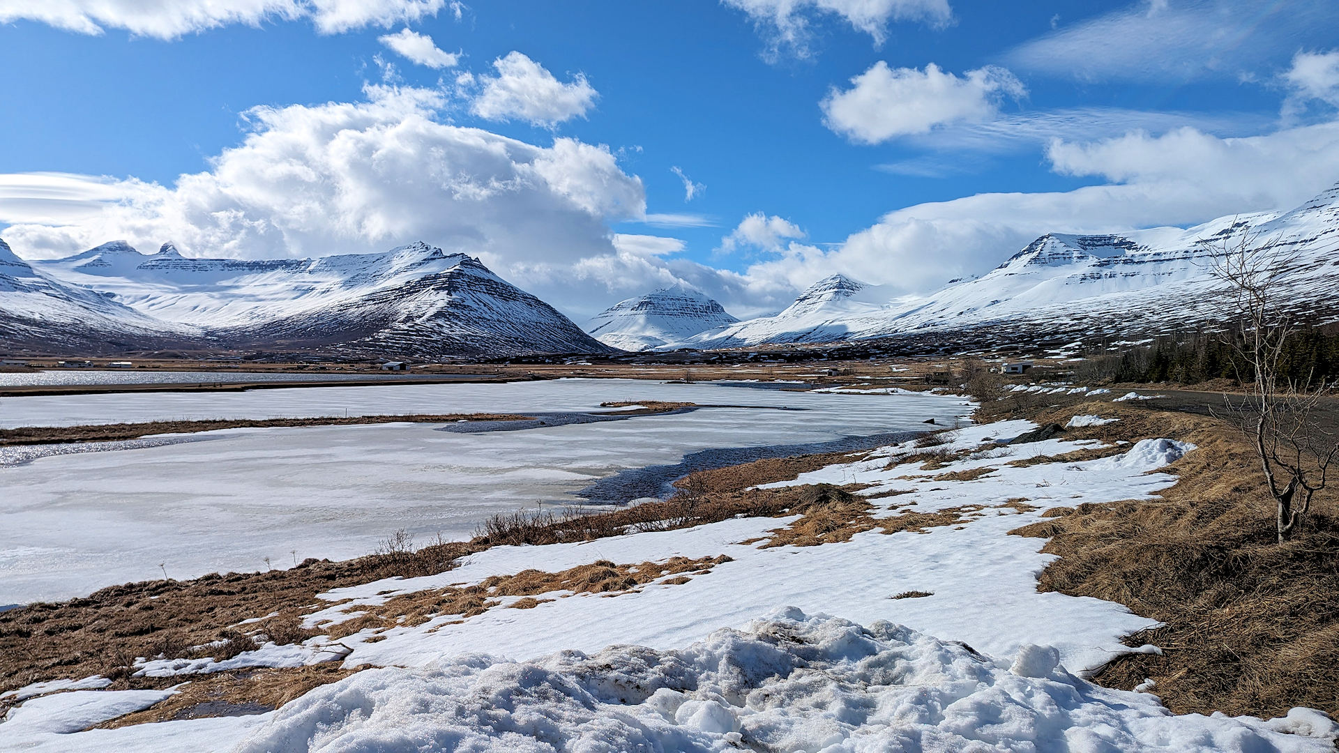 Schneebedeckte Berge und zugefrorener See mit blauem Himmel in Island