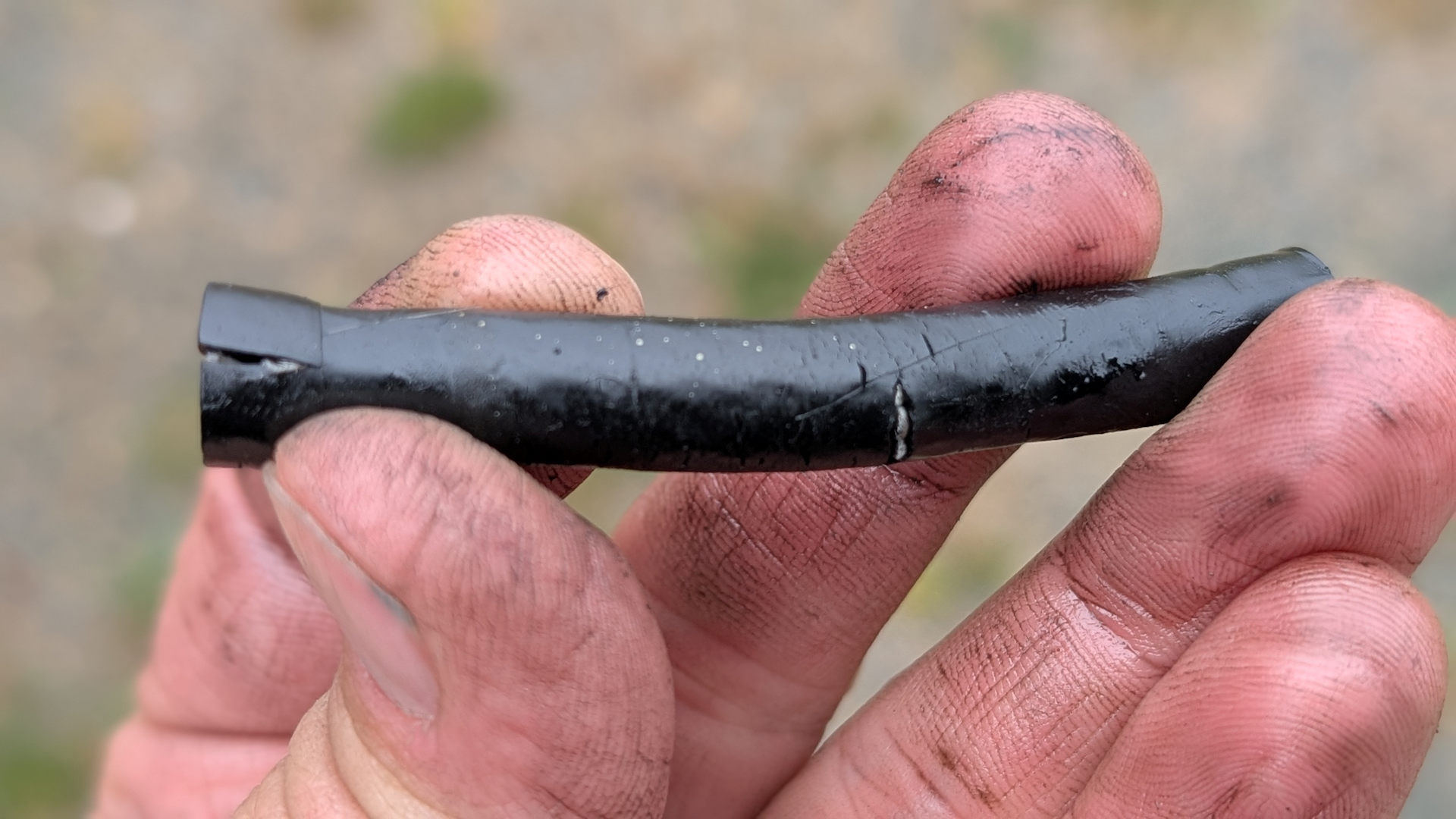 Klassische Reise Reparatur unterwegs: eine Hand hält einen porösen Diesel Schlauch