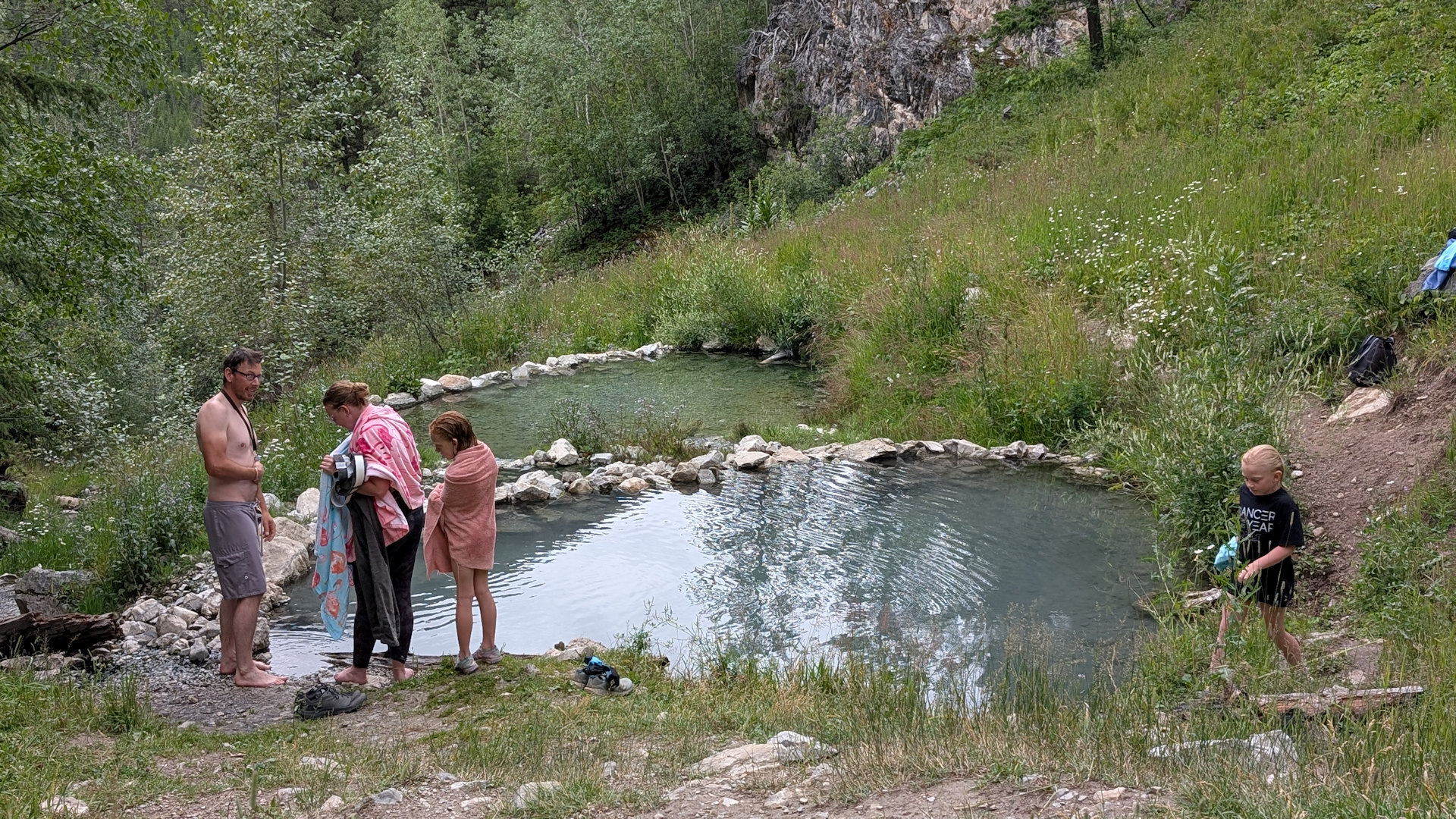 Eine Familie mit zwei Kindern besucht die Ram Creek Hot Springs Ram Creek Hot Springs mit zwei Badebecken in der Natur