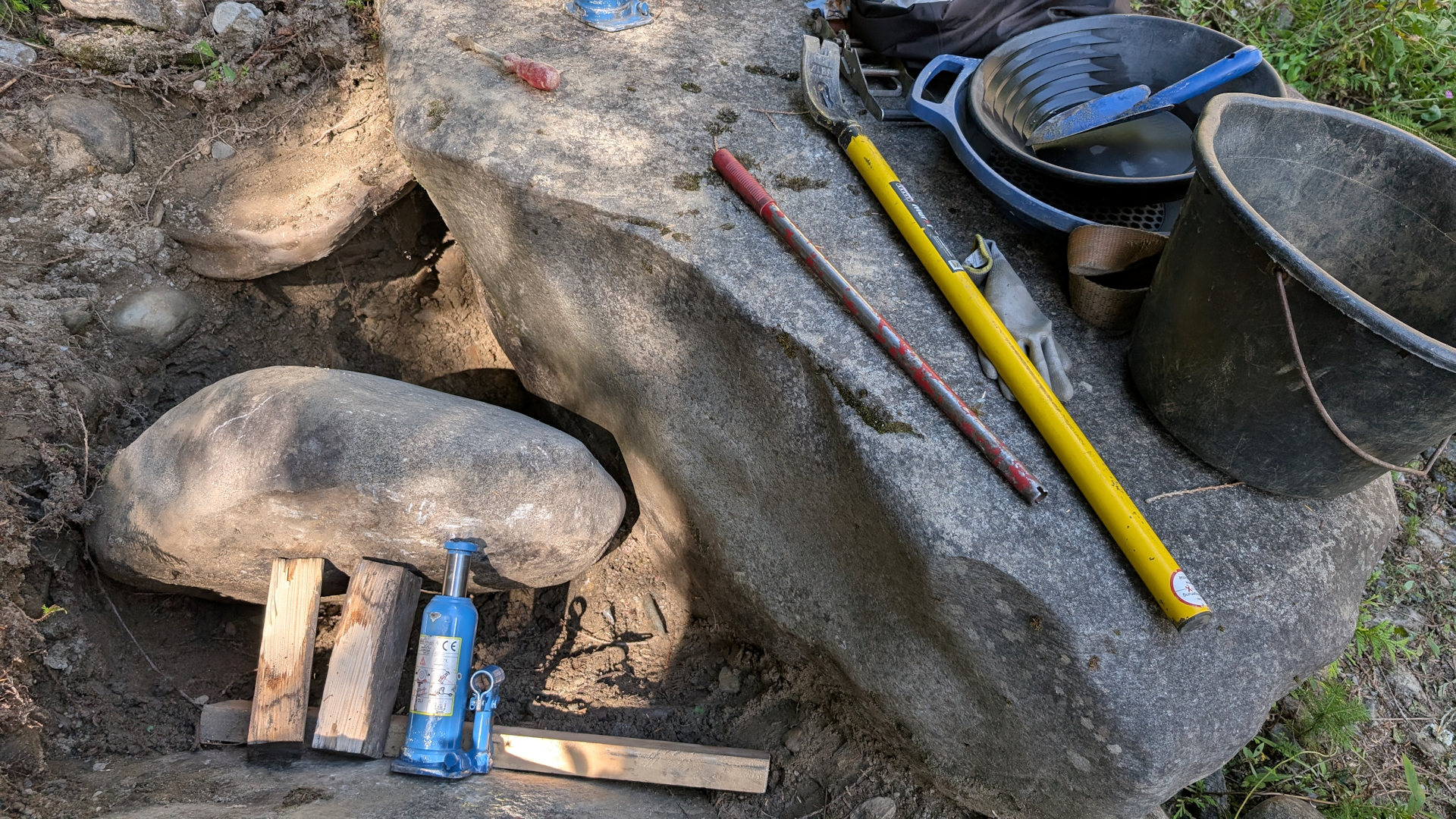 Goldsucharbeiten Werkzeug zwischen dicken Steinen 