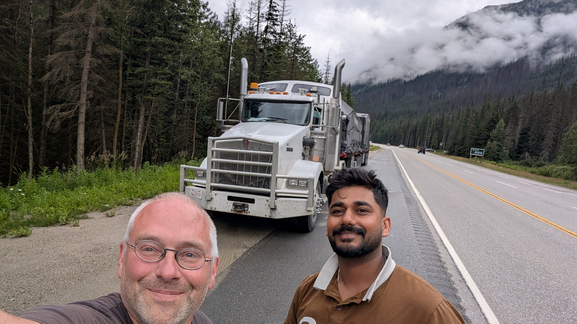 Kenworth LKW in den Rocky Mountains Kanada vor dem zwei glücklich aussehende Männer stehen 