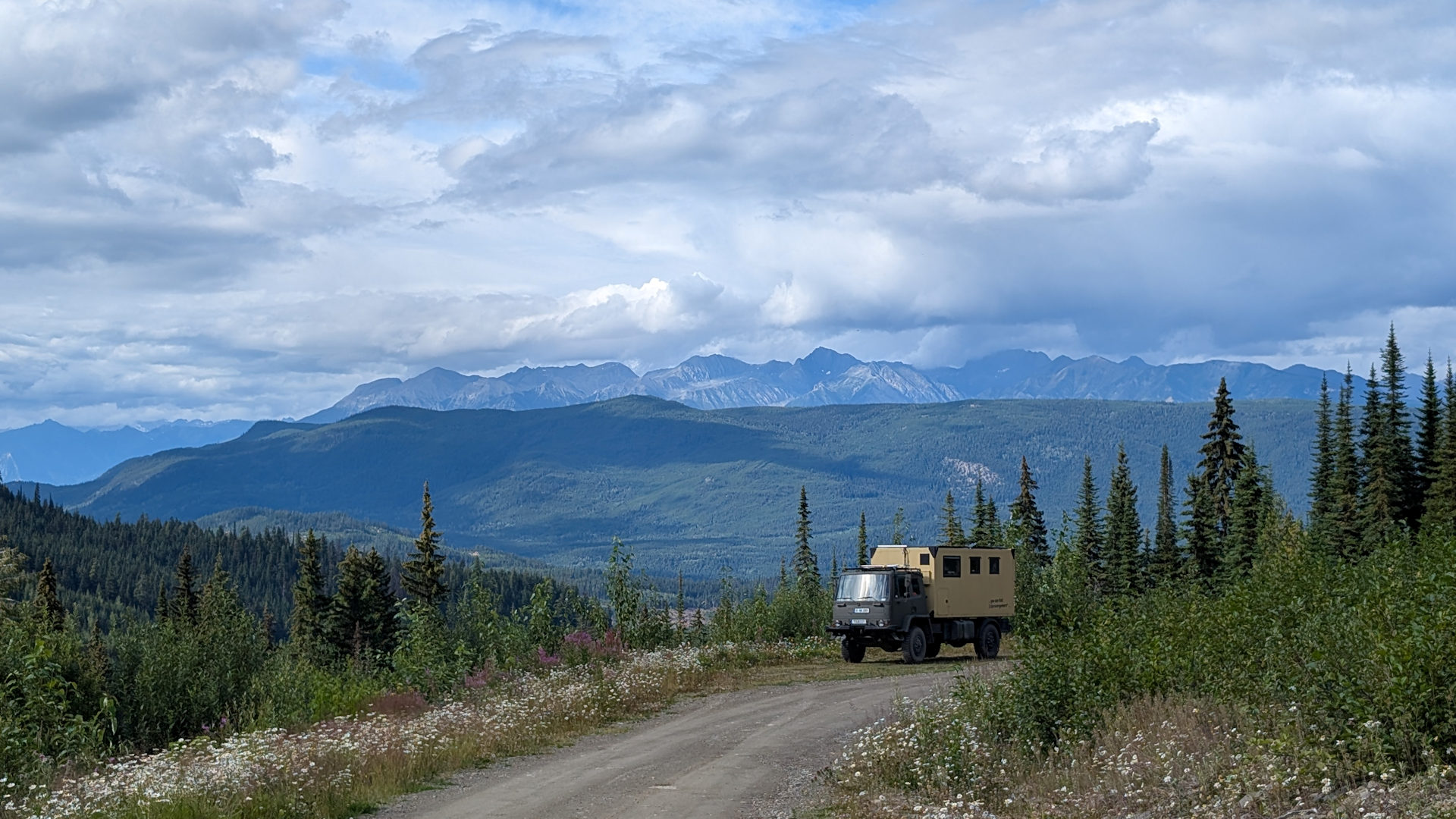 DAF T244 LKW parkt am Rand von einem Weg im Gebirge mit wolkenverhangenem Himmel