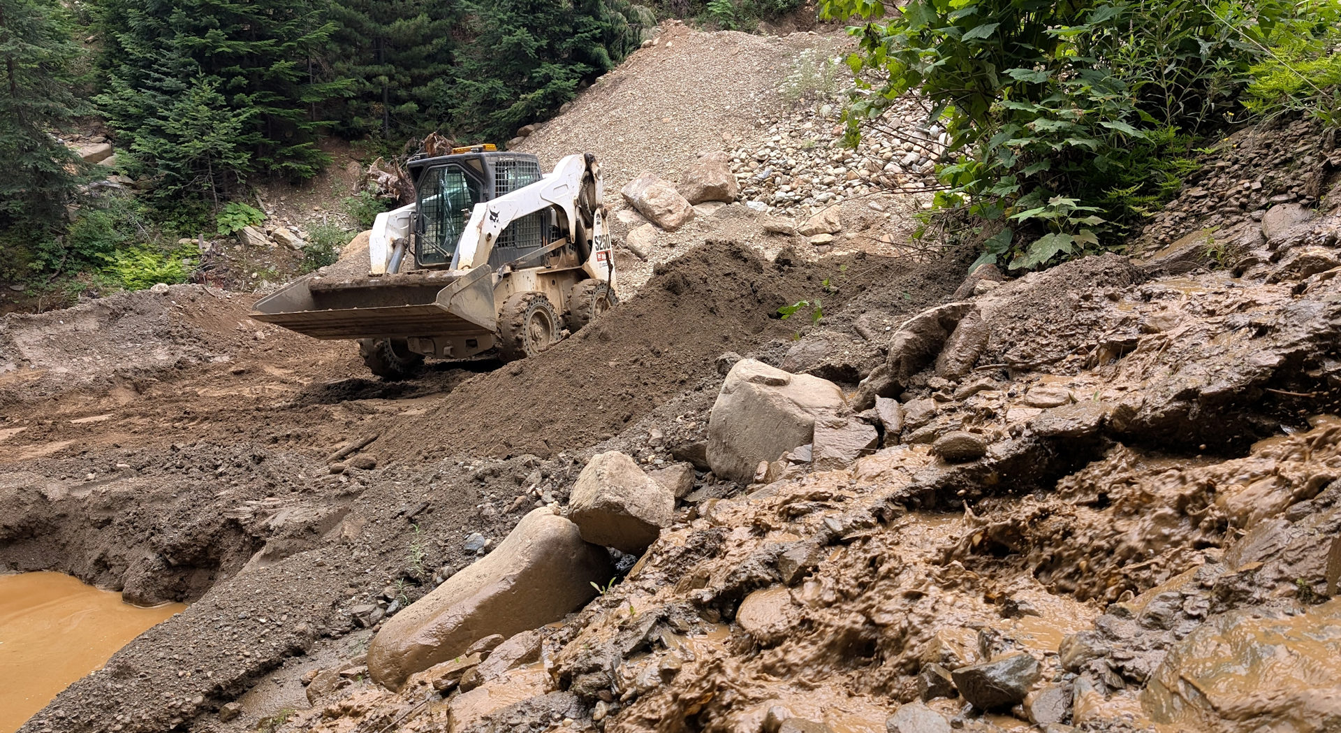 Bobcat 250 Kompaktlader zwischen Sand und Geröllhaufen