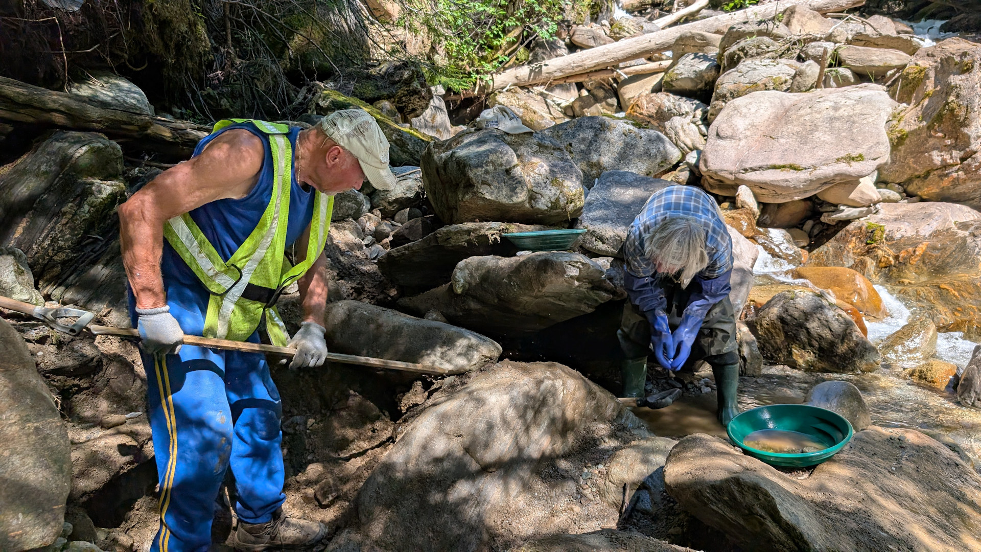 Ein kräftiger Goldgräber stemmt Felsbrocken mit einer Eisenstange beiseite