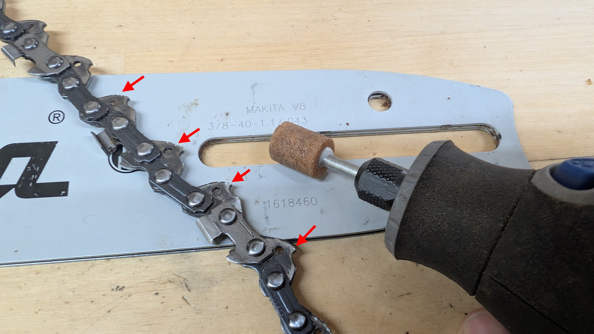 Schwert einer Makita Elektro Kettensäge mit ausgebauter Kette und markierten Beschädigungen