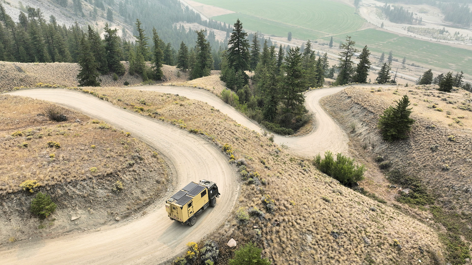 LKW auf einer sich steil durch das Gebirge windenden Piste