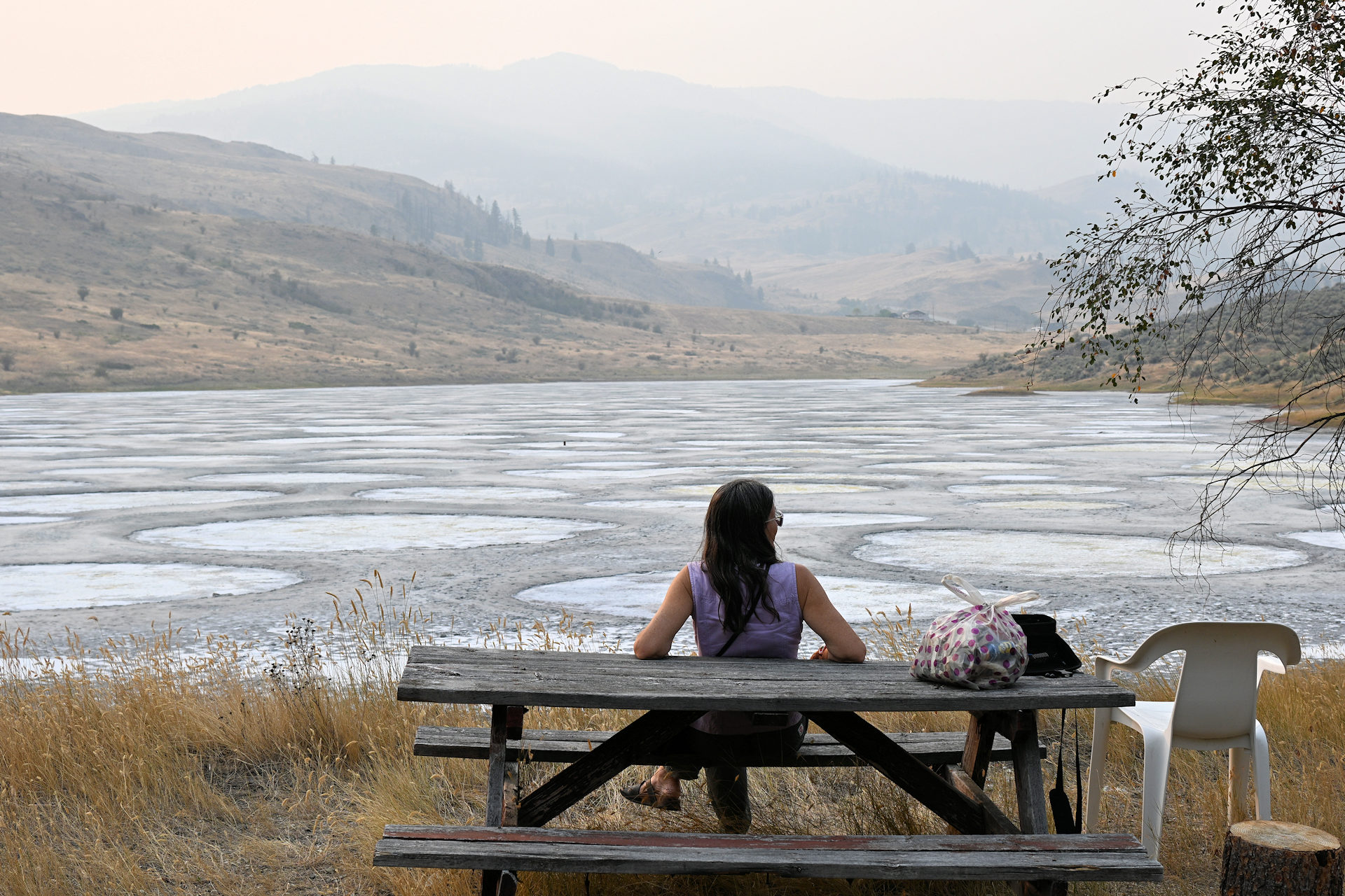 Frau sitzt auf einer Bank am Spotted Lake