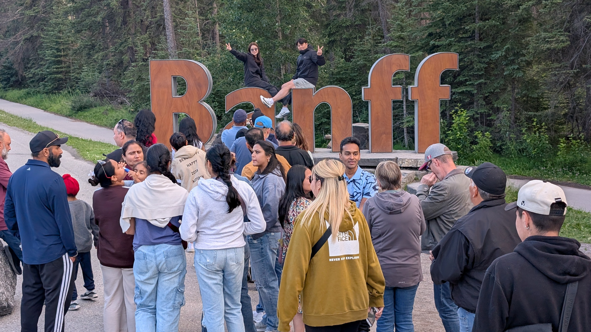 Ortschild von Banff mit vielen Besuchern 