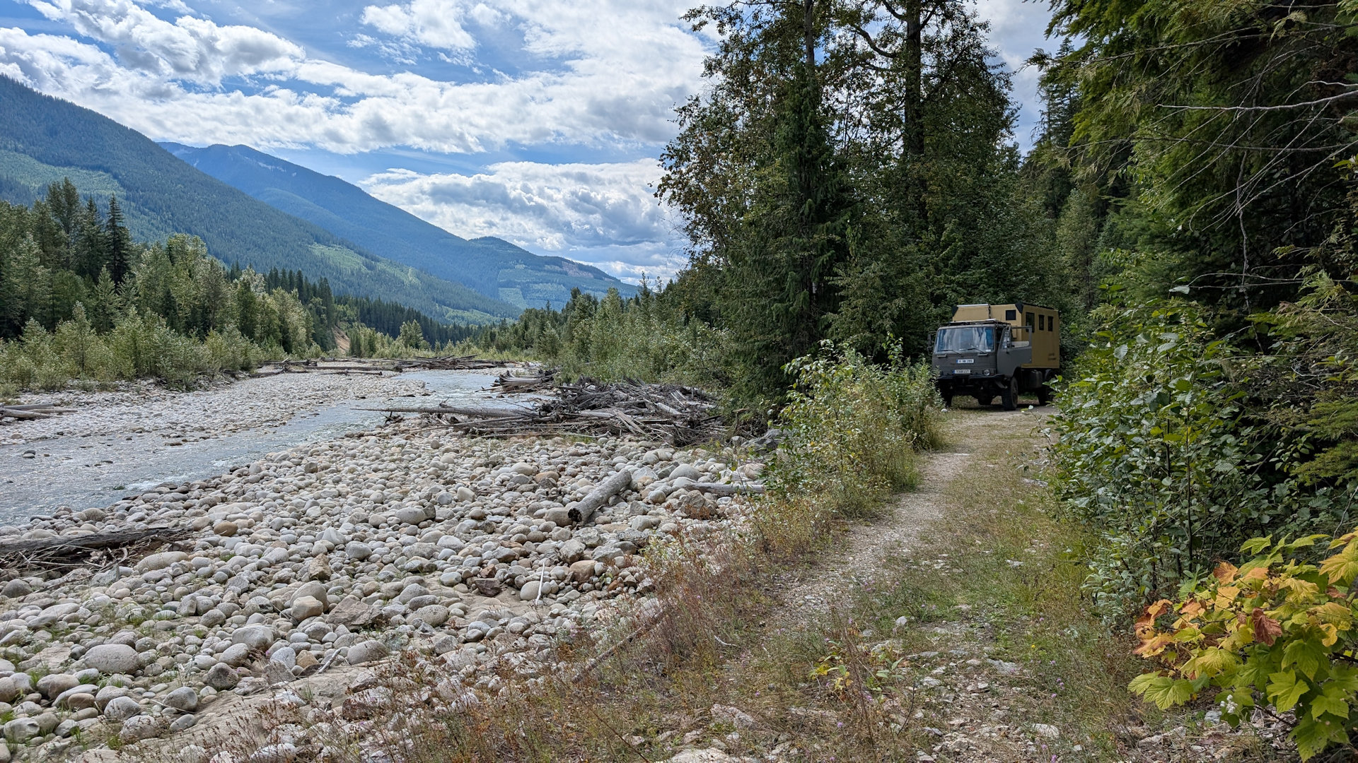 PKW auf einem Weg neben einem Fluss in Kanada