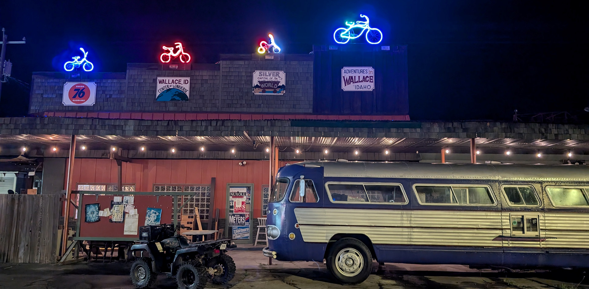 Fassade vom Bike ATV Motorrad verleih in Wallace Idaho mit altem Reisebus und blauer Neobeleuchtung