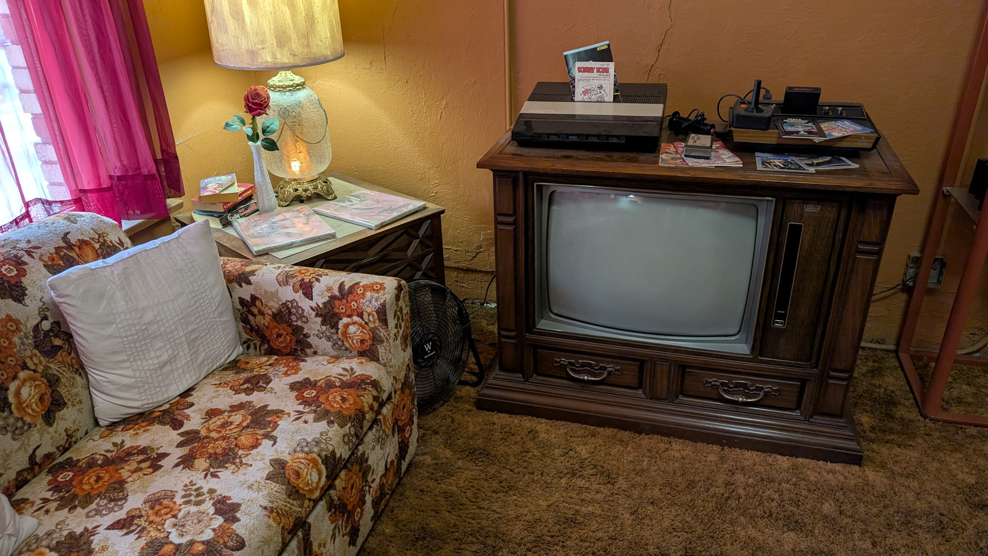 Wohnzimmer mit einem Sofa, Lampe und altem Fernseher mit Atari Spielkonsole