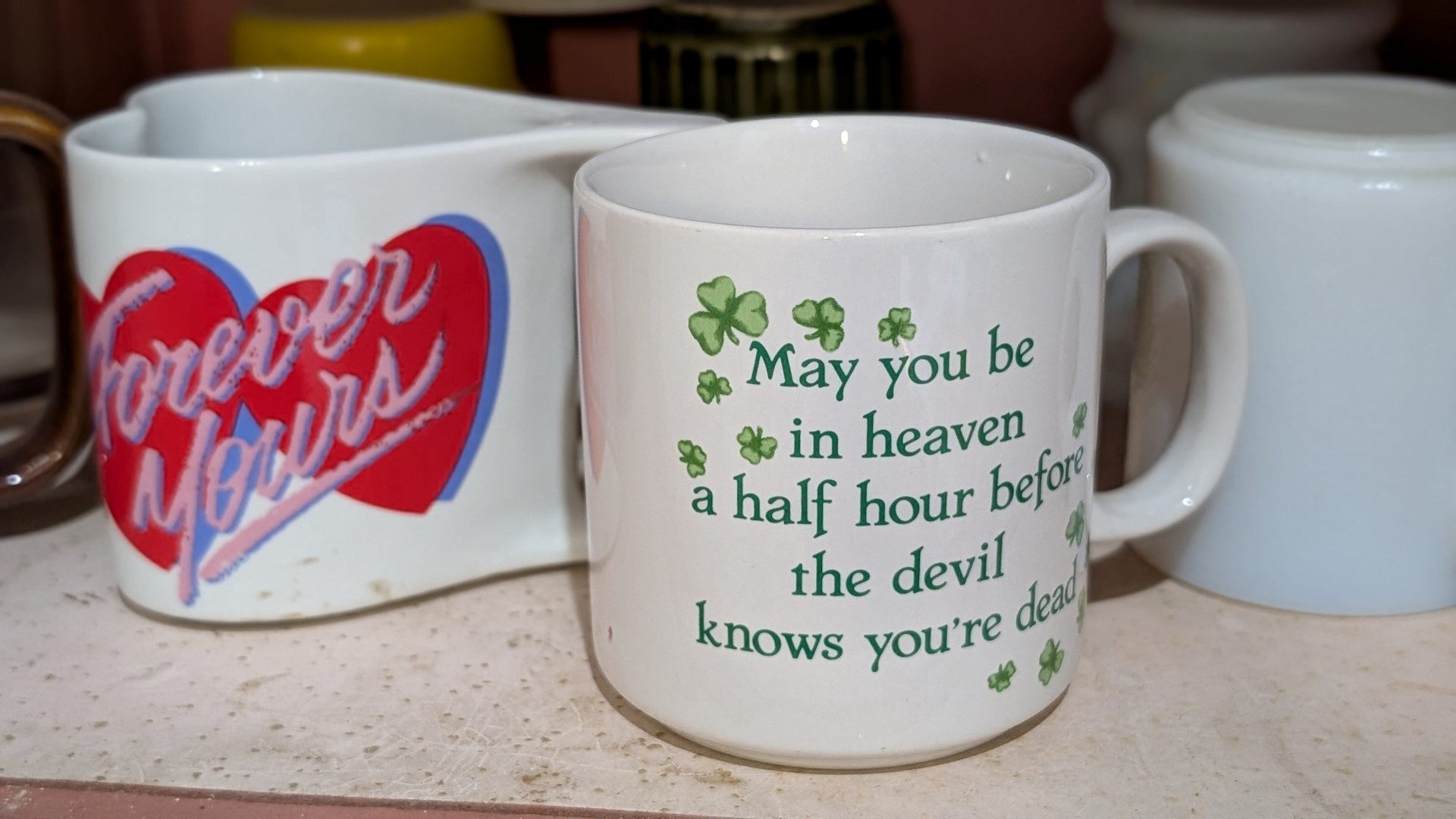 Beschriftete Tassen in einem Küchenregal 