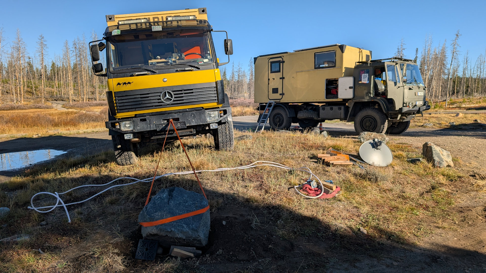 Ein Mercedes 917 zieht mit einem orangenen Spanngurt eine grossen Stein 