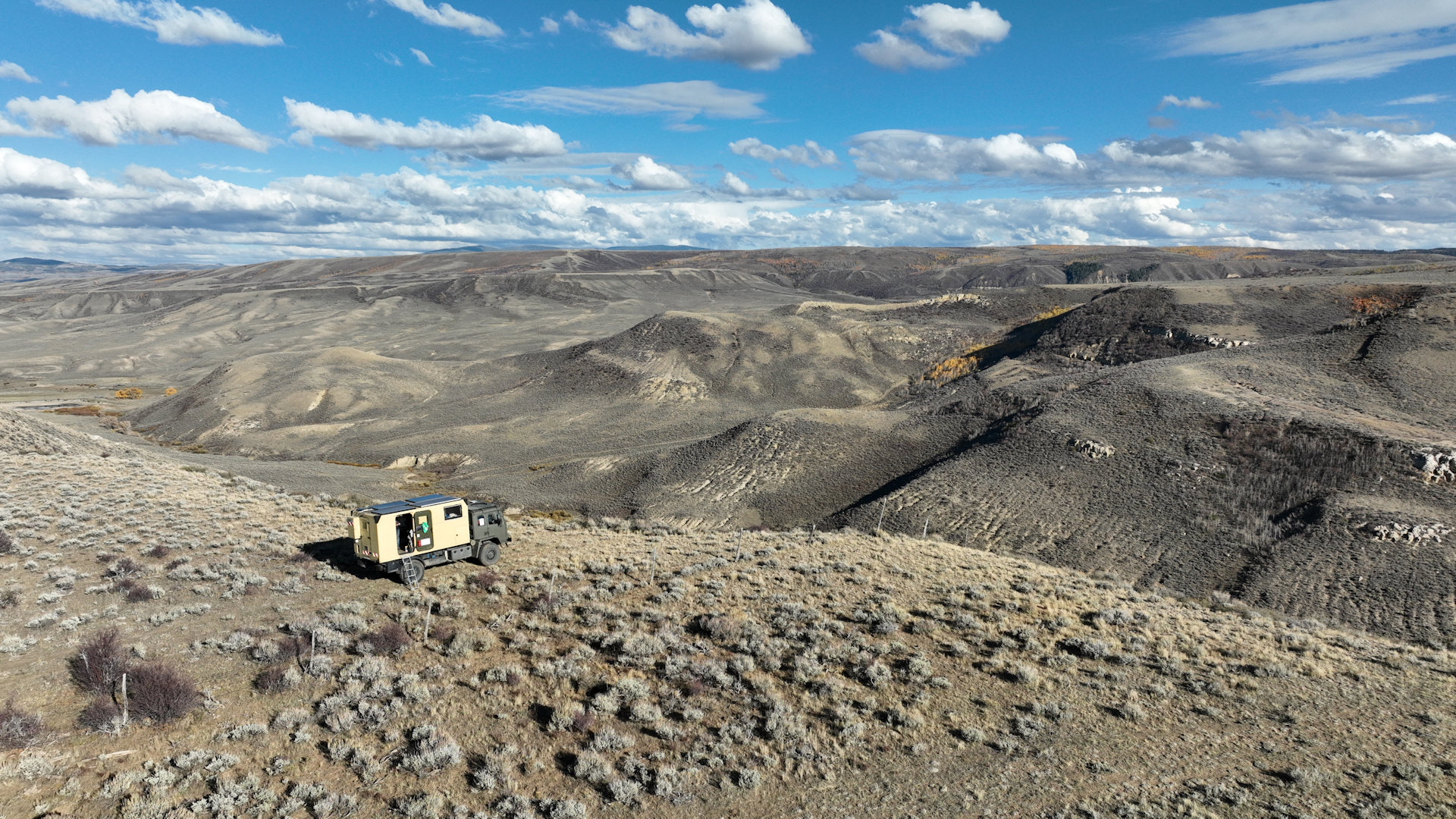 Luftbild vom LKW vor einer grauen Canyon Landschaft mit blauem Wolkenhimmel 