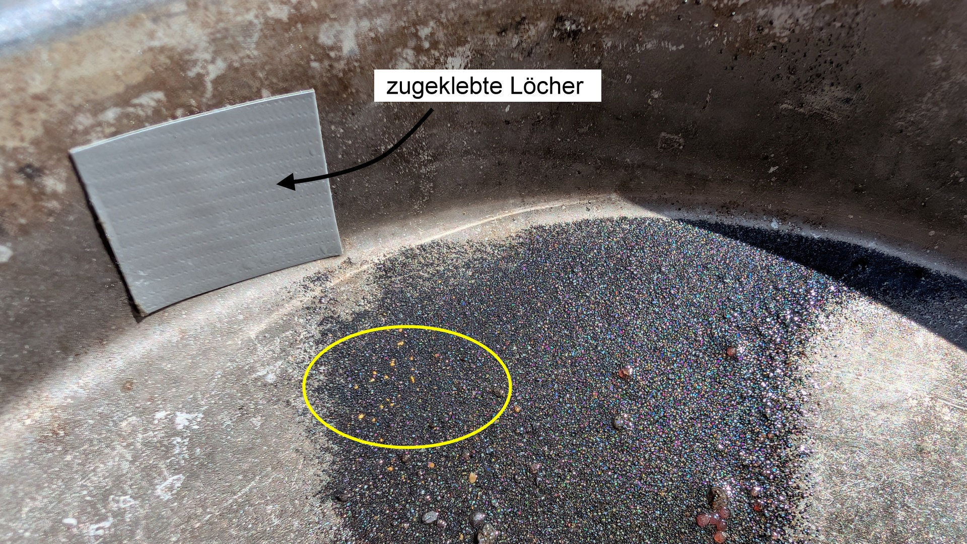Schwarzer Sand mit Goldkrümeln in einem Omnia Alu Deckel