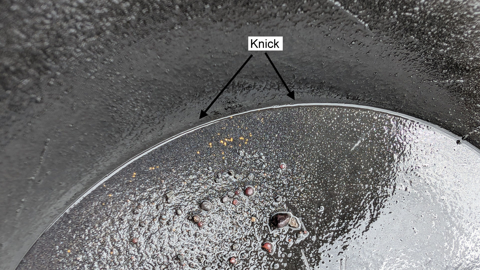Goldkrümel in einer schwarzen Goldwaschpfanne