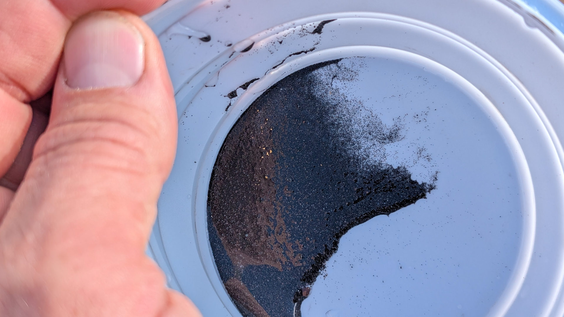 Goldkrümel in einem faltbaren Becher aus Gummi