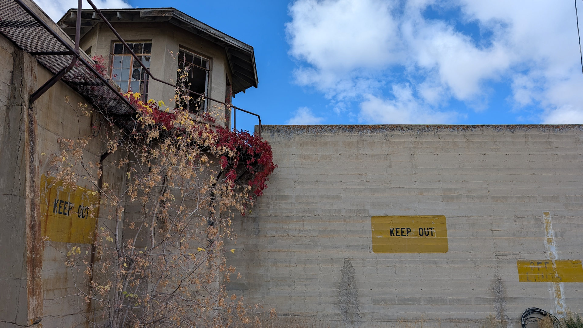 Innenhof vom Wyoming Frontier Prison in Rawlins mit Wächterhaus und gelben keep out Schildern an den Wänden 