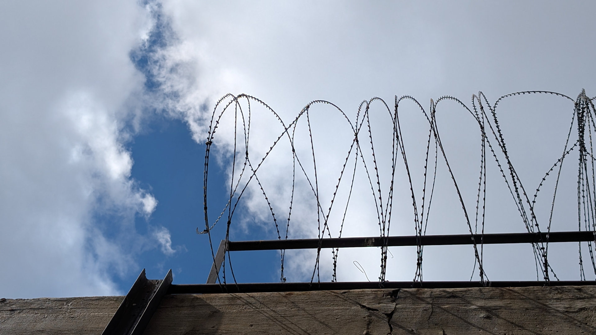Blauer Wolken Himmel mit Stacheldraht 