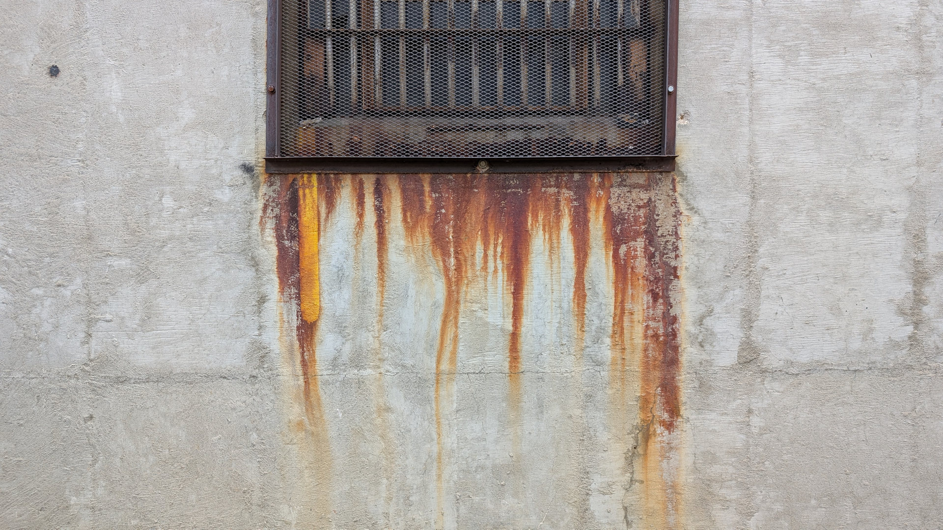 Rostspuren von einem Fenster an einer Betonwand 