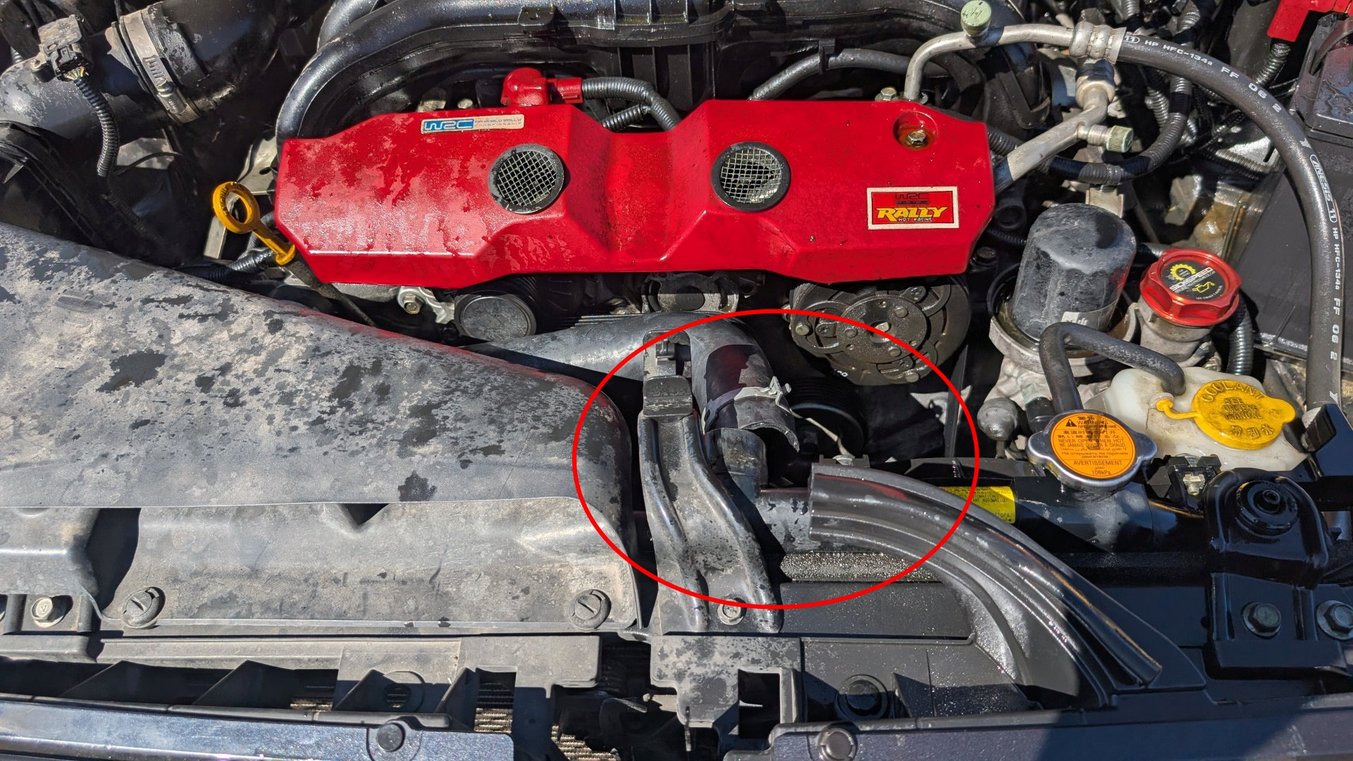 Motorraum mit einem Schlauch der sich gelösst hat. Die Stelle wird mit einem roten Kreis markiert. 