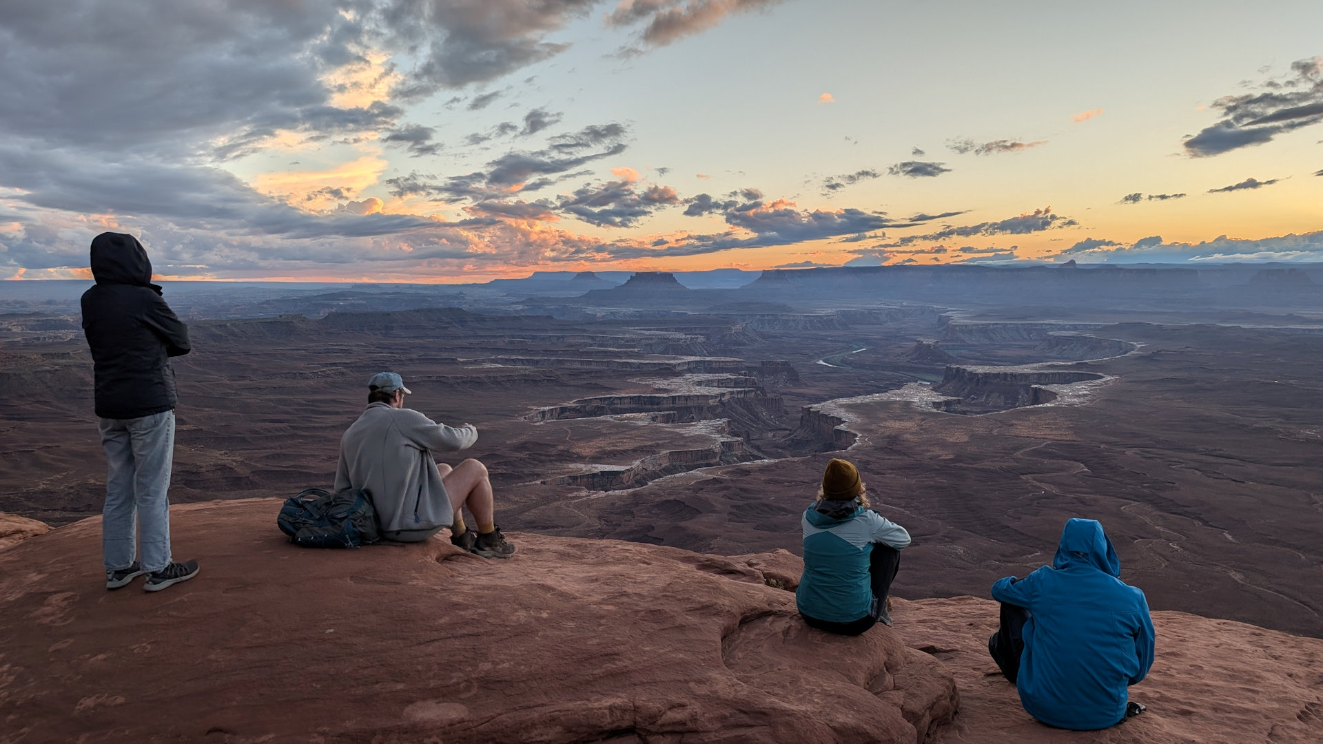 Vier Besucher betrachten vom Green River Aussichtspunkt die zerklüftete Canyonlands Landschaft in Utah 