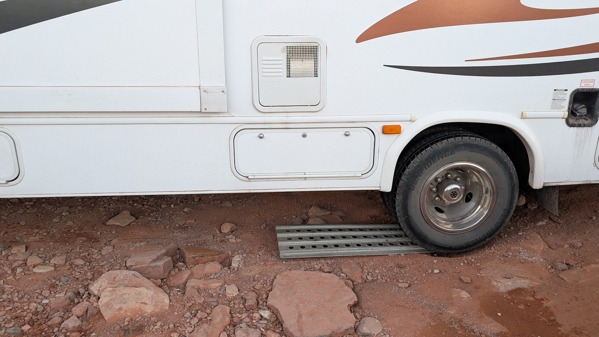Camper steht mit Hinterrad auf einem Sandblech