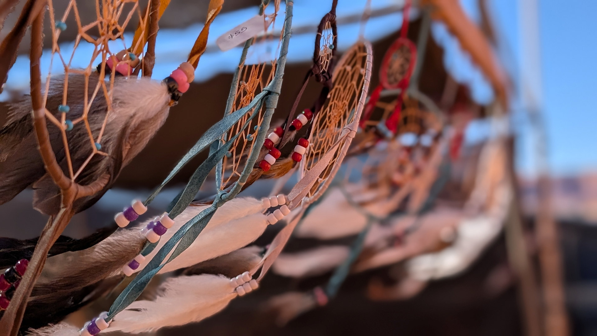 Nahaufnahme von mehreren Traumfängern mit Federn und Perlen