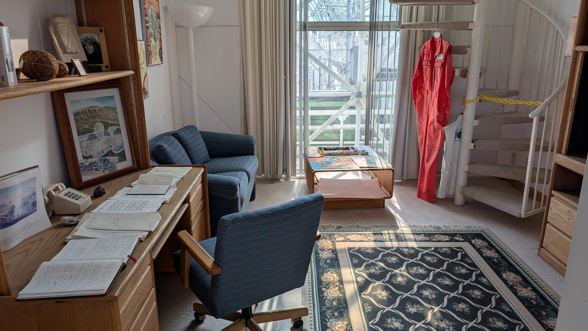 Blick in eine gemütliche Wohnung der Biosphere 2 mit Sofa, Arbeitstisch, Büchern, Teppich und Bildern 