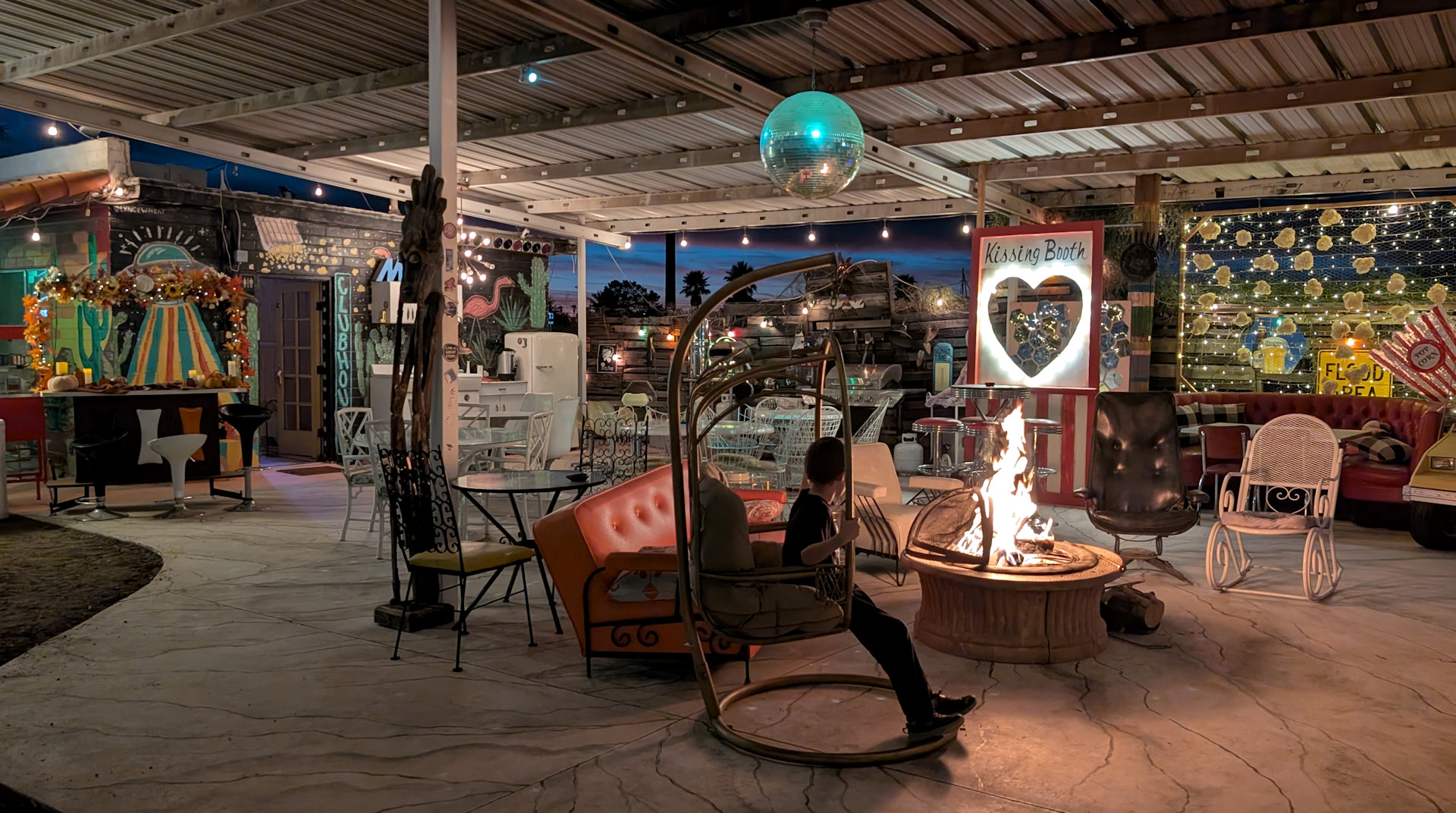 Aussenbereich von El Pais Motel mit bunt beleuchteter Sitzecke und Lagerfeuer