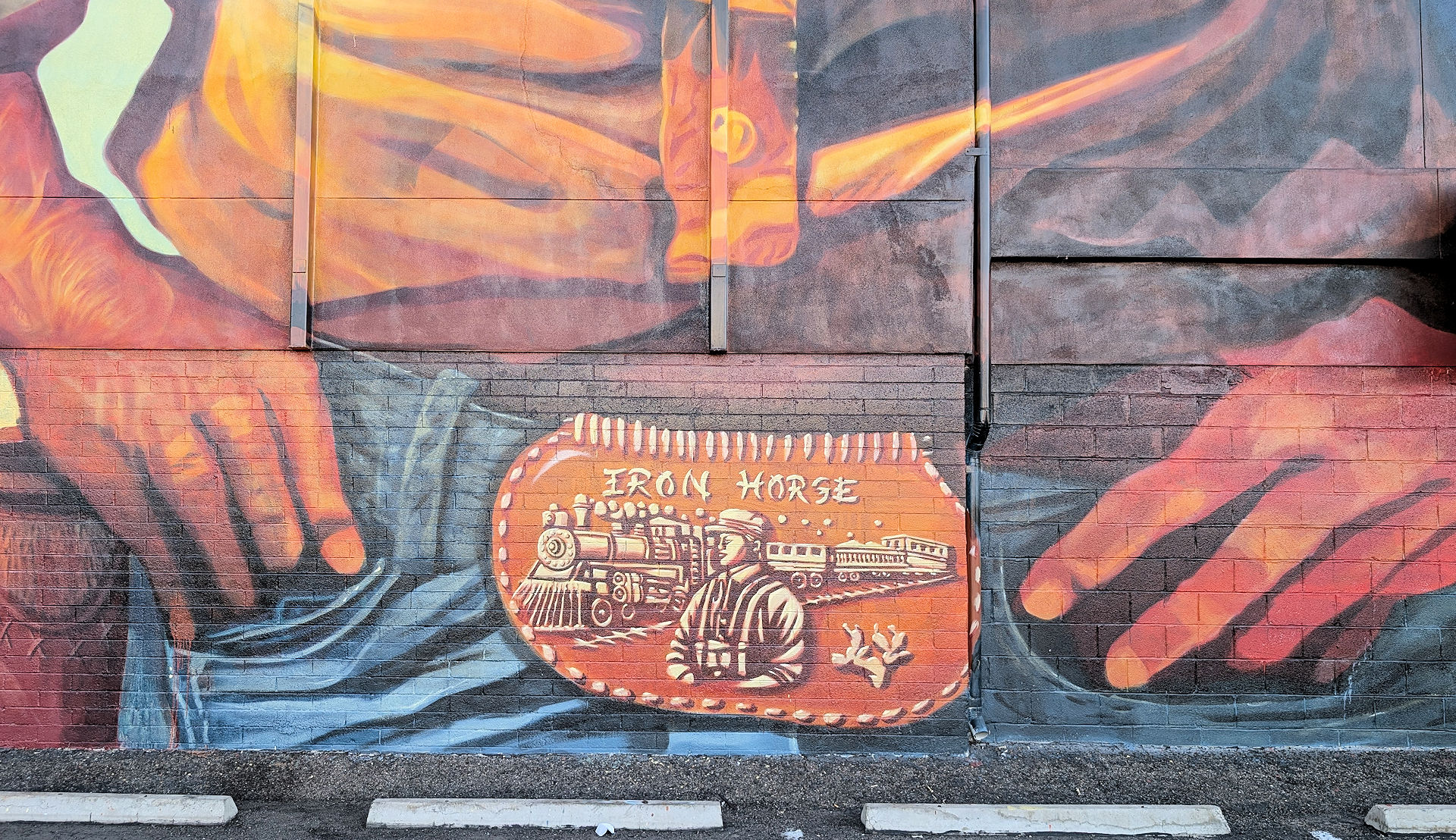 Detailaufnahme einer gemalten Gürtelschnalle mit einem Eisenbahnzug