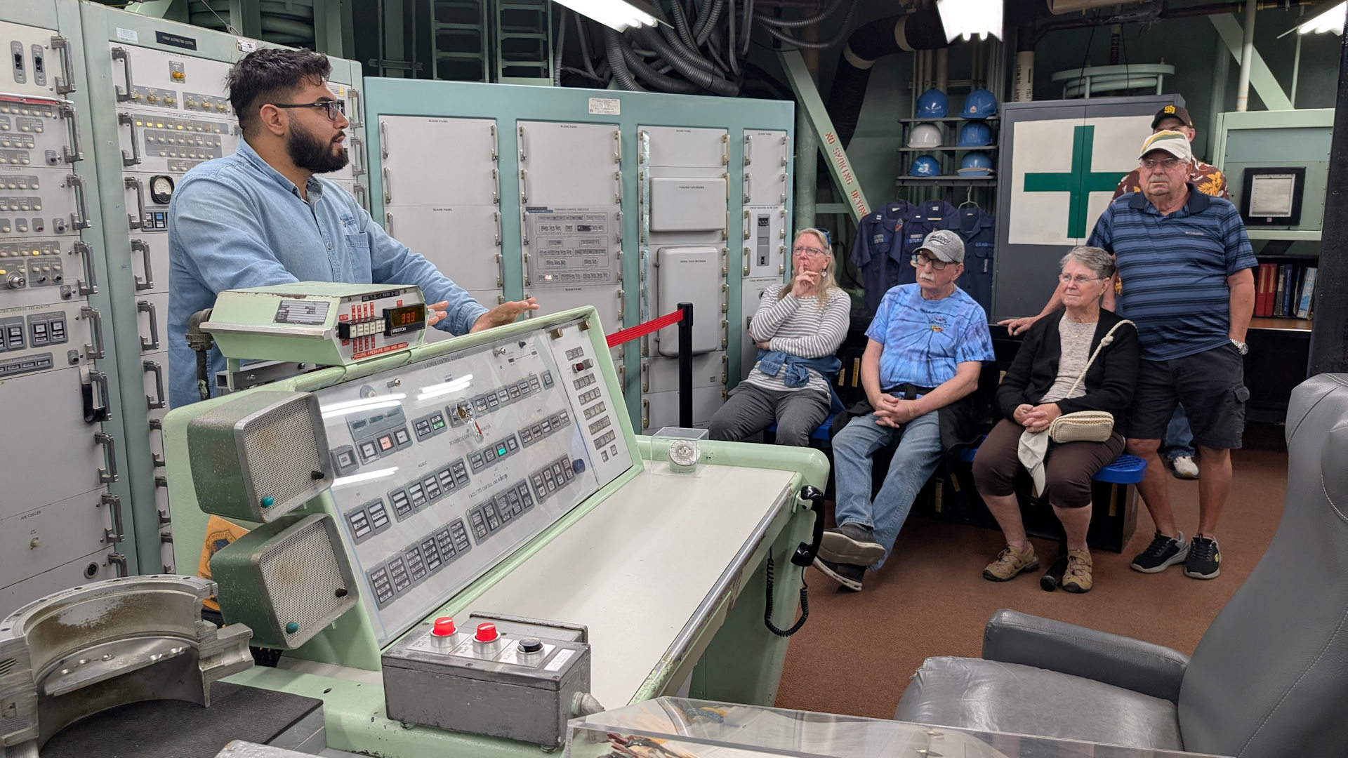 Fünf Menschen stehen um ein Kontrollpult im Atomraketen Bunker  herum 