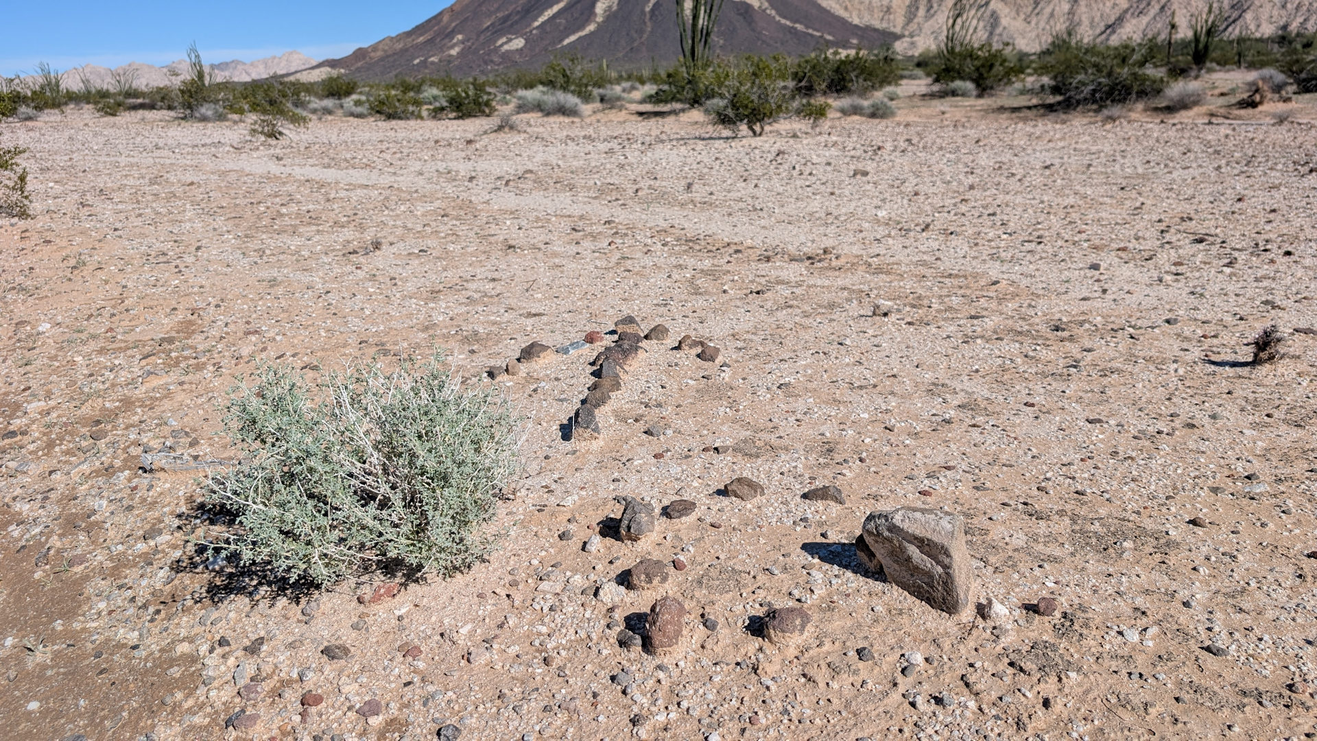 Pfeil aus Steinen und viereckiges Symbol aus Steinen in der Sonara Wüste