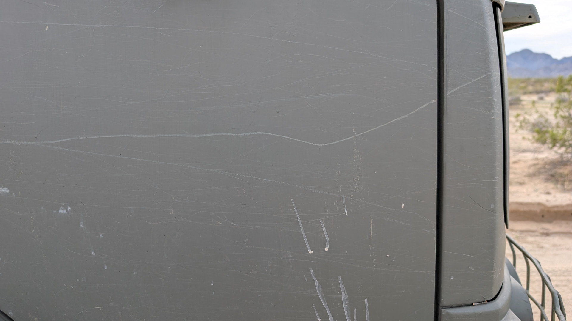 Kratzer in einer olivfarbenen LKW Tür 