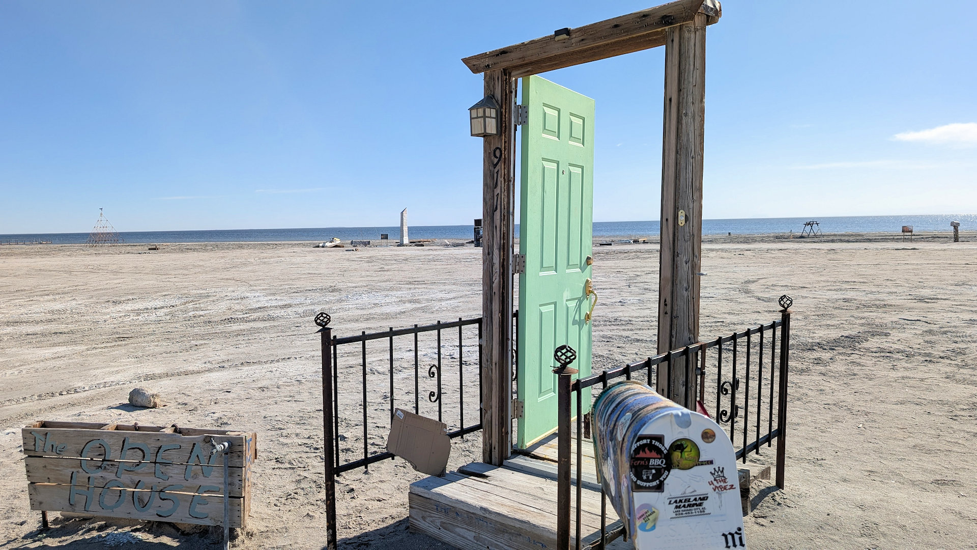 Open House Kunstwerk aus einer offenen hellgrünen Tür am Strand von Bombay Beach