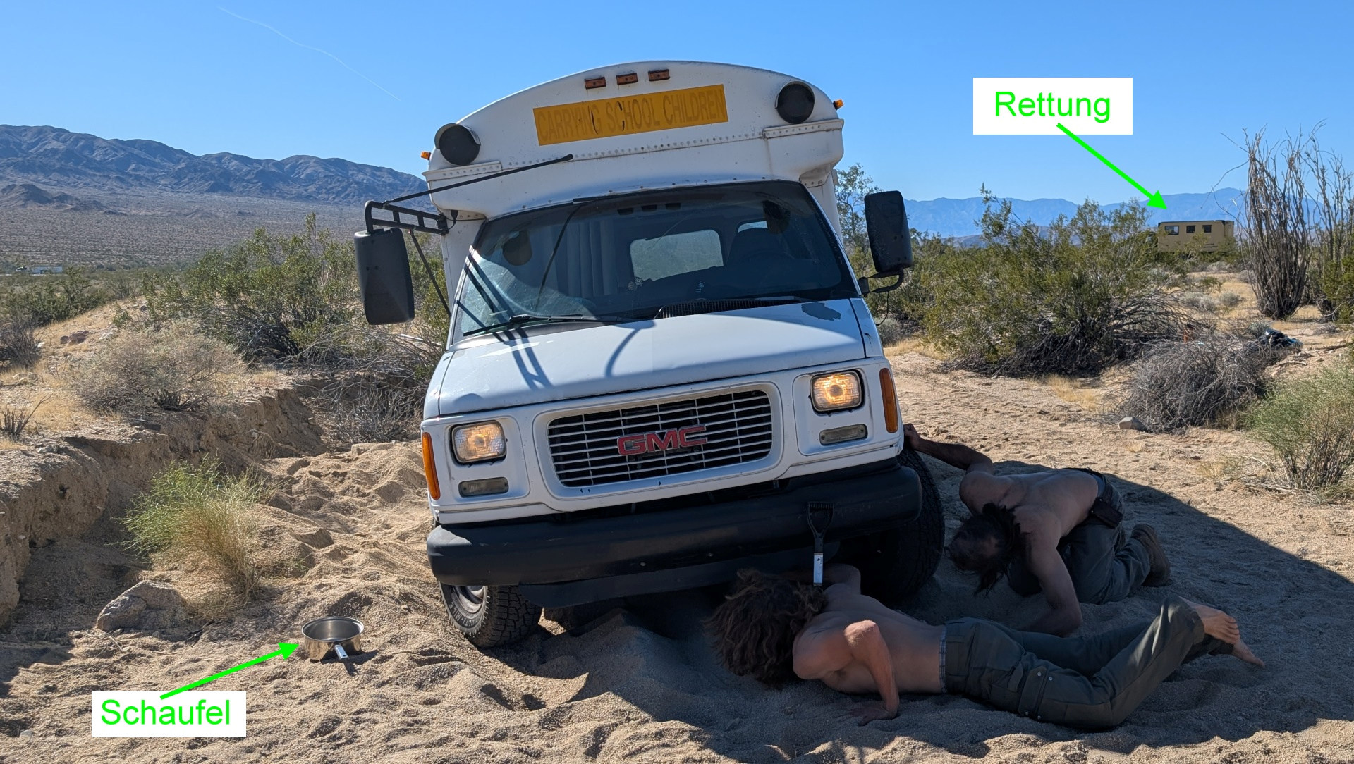 Zwei Männer graben bei einer Offroad Bergung einen GMC Kleinbus Offroad aus