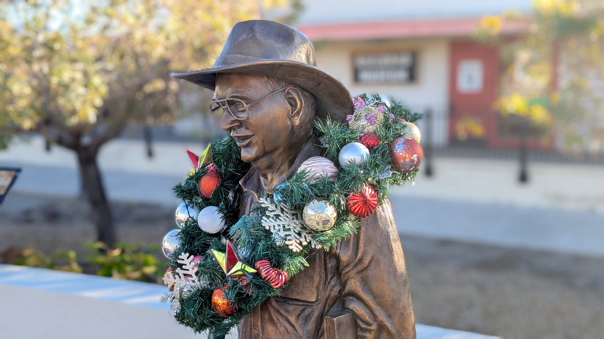 Bronzefigur mit einem Weihnachtskranz geschmückt 
