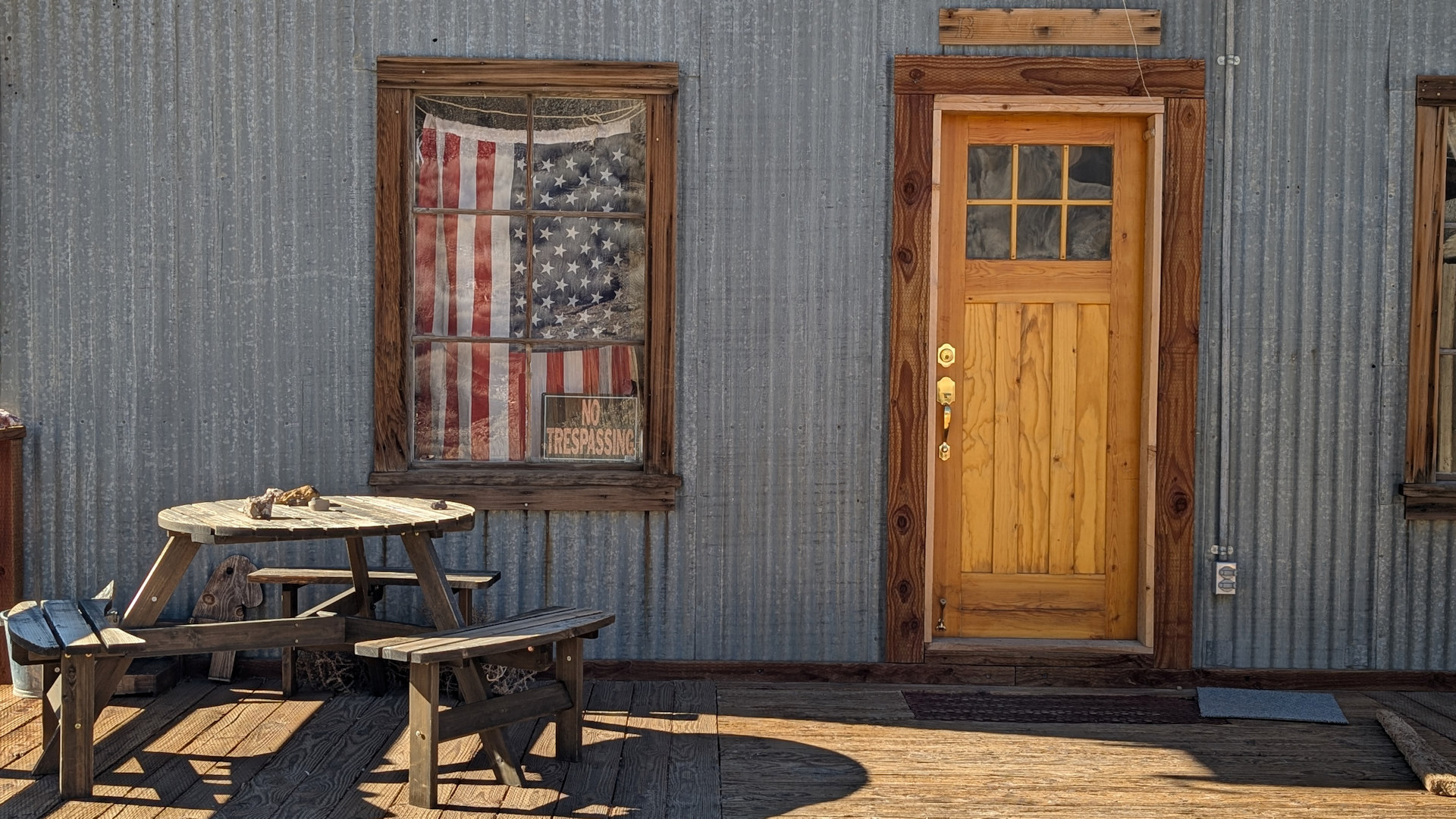 Wellblechhütte mit Holztür und amerikanischer Flagge im Fenster