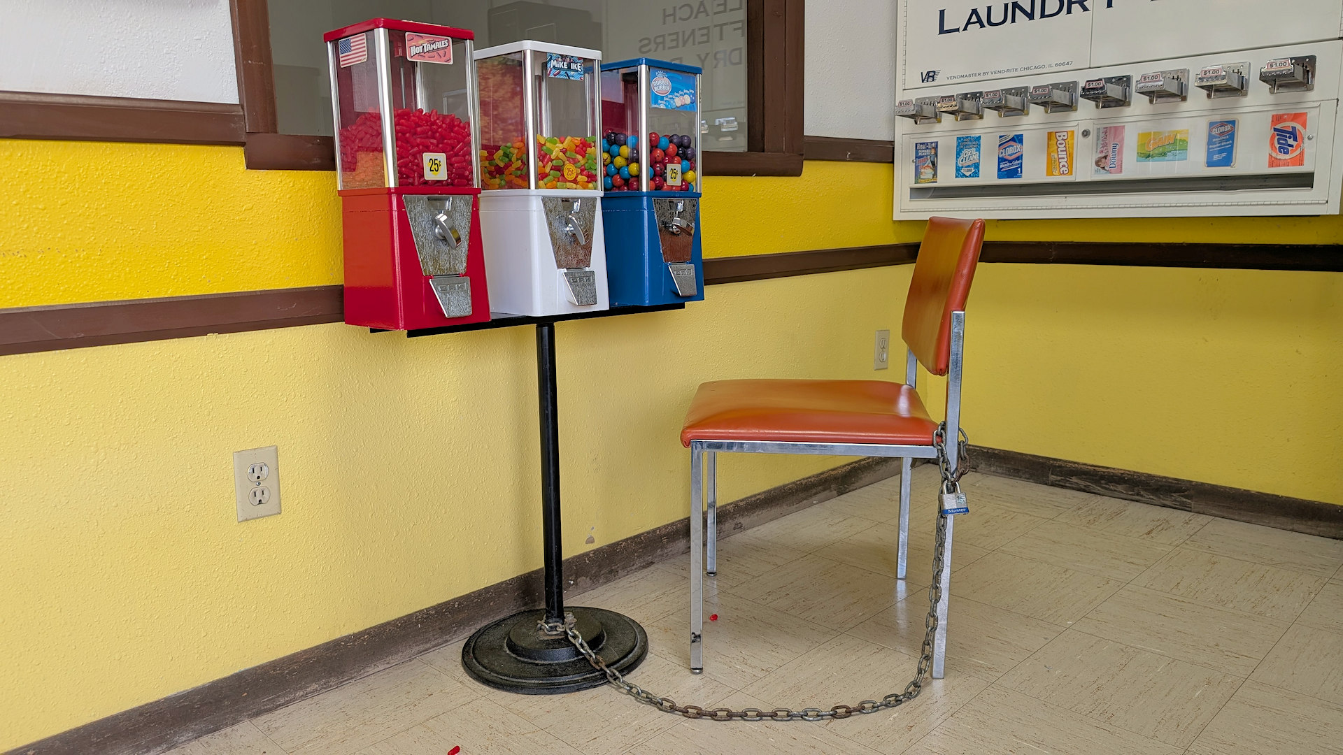 Kaugummi Automat an dem ein Stuhl mit einer Kette befestigt ist